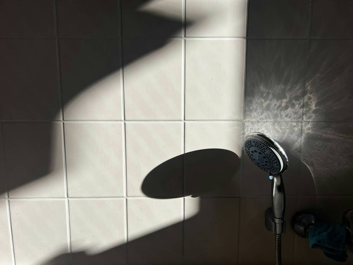 Diagram showing optimal dual shower head placement: rain head centered overhead at 80 inches, handheld mounted at 48 inches on side wall, diverter valve within arm's reach