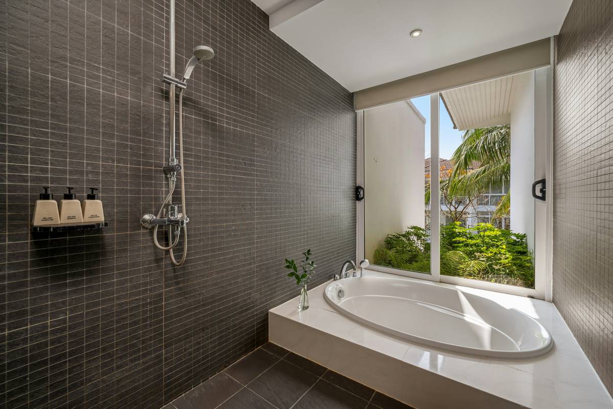 Dual headed shower head installed in modern bathroom with overhead rain fixture and handheld wand on slide bar