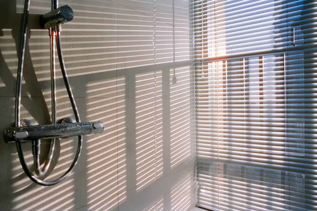 dual shower head adjustable height system installed in modern bathroom with slide bar and overhead rain head